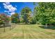 Expansive backyard with a mature tree, a green lawn, and a fence at 3700 Tom Brewer Rd, Loganville, GA 30052