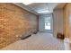 Basement interior with brick wall, carpet and natural light from the window at 3700 Tom Brewer Rd, Loganville, GA 30052