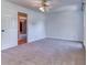Bedroom with carpet, ceiling fan, white doors and trim, and an open doorway at 3700 Tom Brewer Rd, Loganville, GA 30052