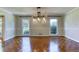 A dining room featuring detailed molding, a stylish chandelier, and glossy parquet flooring at 3700 Tom Brewer Rd, Loganville, GA 30052