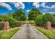 Long driveway framed by lush greenery and brick columns, leading to a secluded property at 3700 Tom Brewer Rd, Loganville, GA 30052