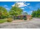 Well-maintained single-story home featuring brick exterior, mature landscaping, and large driveway at 3700 Tom Brewer Rd, Loganville, GA 30052