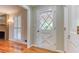 Hallway featuring a decorative glass door, window with shutters, and hardwood floors at 3700 Tom Brewer Rd, Loganville, GA 30052