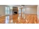 Bright living room featuring hardwood floors, a brick fireplace, and shuttered windows at 3700 Tom Brewer Rd, Loganville, GA 30052