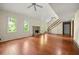 A spacious living room with high ceilings, hardwood floors, stairs to an open loft, and a stone fireplace at 70 Juliana Dr, Ellenwood, GA 30294