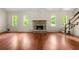 A spacious living room with high ceilings, hardwood floors, stairs to an open loft, and a stone fireplace at 70 Juliana Dr, Ellenwood, GA 30294