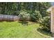 A nice, flat backyard with a wood fence and a tier with green plants and green grass at 1055 Avalon Dr, Lawrenceville, GA 30044