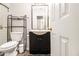 View of the bathroom with a nice sink, toilet, and shelving unit next to the shower with a glass door at 1055 Avalon Dr, Lawrenceville, GA 30044