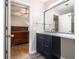 Bathroom with a granite countertop vanity, blue cabinets, open doorway to bedroom, and mirror at 1055 Avalon Dr, Lawrenceville, GA 30044