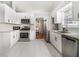 Bright kitchen featuring white cabinets, stainless steel appliances, and granite countertops at 1055 Avalon Dr, Lawrenceville, GA 30044