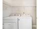 Convenient laundry room with a washer, dryer, and overhead shelving for storage at 1055 Avalon Dr, Lawrenceville, GA 30044