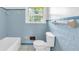 Bathroom featuring blue tile, classic white toilet and bath at 1189 E Fayetteville Rd, Riverdale, GA 30296