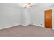 Neutral bedroom with a ceiling fan, hardwood door, and carpet at 1189 E Fayetteville Rd, Riverdale, GA 30296