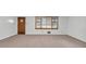 Cozy living room with neutral carpet, window, and diamond pane door at 1189 E Fayetteville Rd, Riverdale, GA 30296