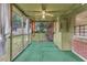 Enclosed sunroom featuring green carpet, ceiling fan, and backyard view at 1189 E Fayetteville Rd, Riverdale, GA 30296