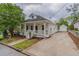Inviting white home with a covered front porch, a long driveway, and detached garage at 1555 New Ne St, Atlanta, GA 30307