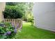 Backyard featuring a well-maintained lawn, a wooden fence, mature trees, and blooming hydrangeas at 3053 Shadow Walk Ln, Tucker, GA 30084