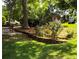 Picturesque backyard featuring mature trees, lush green grass, and terraced flower beds at 10815 Tuxford Dr, Alpharetta, GA 30022