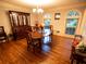 Traditional dining room with hardwood floors, chandelier, and a large china cabinet at 10815 Tuxford Dr, Alpharetta, GA 30022