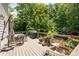 Outdoor deck with wicker chairs, a table, an umbrella, and a grill, surrounded by lush greenery at 3045 Moss Stone Lane Sw Ln, Marietta, GA 30064