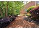 Beautiful backyard with brick home, and landscape featuring various plants and trees at 3045 Moss Stone Lane Sw Ln, Marietta, GA 30064