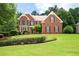 Charming brick home with manicured lawn and mature landscaping featuring black window shutters at 3045 Moss Stone Lane Sw Ln, Marietta, GA 30064