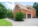 Home exterior featuring a two-car garage, lush greenery, and brick facade at 3045 Moss Stone Lane Sw Ln, Marietta, GA 30064