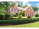 Charming brick home with manicured lawn and mature landscaping featuring black window shutters at 3045 Moss Stone Lane Sw Ln, Marietta, GA 30064