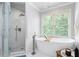 Luxurious bathroom featuring a soaking tub, glass shower, and natural light from large windows at 3045 Moss Stone Lane Sw Ln, Marietta, GA 30064