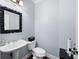 Traditional powder room with pedestal sink, dark frame mirror, and neutral wall color at 3045 Moss Stone Lane Sw Ln, Marietta, GA 30064