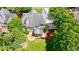 Aerial view of a home showcasing a backyard with mature trees, fire pit area, and spacious patio at 4310 Granby Way, Marietta, GA 30062
