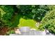 Aerial view of a lush backyard featuring a well-maintained lawn, fire pit area and mature trees at 4310 Granby Way, Marietta, GA 30062