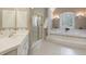 Bathroom featuring a luxurious soaking tub, walk-in shower, and sink with white cabinets at 4310 Granby Way, Marietta, GA 30062