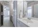Bathroom with white cabinets, mirror, wallpaper, quartz countertop, and view into adjacent bedroom at 4310 Granby Way, Marietta, GA 30062