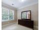 Bright bedroom featuring large window, neutral walls, and dark wood dresser with large mirror at 4310 Granby Way, Marietta, GA 30062