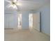 Carpeted bedroom featuring a fan, doors to a bathroom and hallway, and blue accent paint at 4310 Granby Way, Marietta, GA 30062