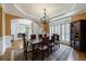Elegant dining room with a wooden table, chandelier, hardwood floors, and cabinet at 4310 Granby Way, Marietta, GA 30062