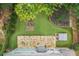 Aerial view of a backyard featuring a stone patio, hot tub, planting beds, and green lawn at 10980 Pinehigh Dr, Alpharetta, GA 30022