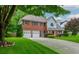 Two-story brick home with well-maintained landscaping, a driveway, and an attached two-car garage at 10980 Pinehigh Dr, Alpharetta, GA 30022