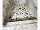 Close up of the shower floor featuring pebble stone tiling at 10980 Pinehigh Dr, Alpharetta, GA 30022