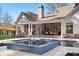 A luxurious backyard features a pool and spa area with an inviting covered patio and beautifully manicured landscaping at 113 Laurel Brook Ln, Canton, GA 30115