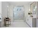 Elegant bathroom featuring a glass shower with decorative tile, marble countertops, and stylish lighting fixtures at 113 Laurel Brook Ln, Canton, GA 30115