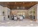 An elegant covered patio features brick walls, herringbone floors, stone fireplace, and ample seating for outdoor entertaining at 113 Laurel Brook Ln, Canton, GA 30115