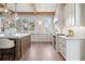 Bright kitchen featuring custom white cabinets, marble countertops, stainless steel appliances, and wood beam accents at 113 Laurel Brook Ln, Canton, GA 30115