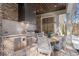 Outdoor kitchen with brick and stone finishes, a built-in grill, and seating area for entertaining at 113 Laurel Brook Ln, Canton, GA 30115