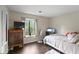 Comfortable bedroom with dark wood floor, a large window, and light colored walls at 1271 Muirforest Ln, Stone Mountain, GA 30088