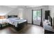 Well-lit bedroom featuring dark furniture, wood floors, and a large window at 1271 Muirforest Ln, Stone Mountain, GA 30088