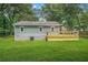 Green backyard featuring light green siding and a new wooden deck at 1675 White Oak Way, Decatur, GA 30032