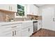 Bright kitchen boasts white cabinetry, stainless steel appliances, quartz countertops, and backsplash tile at 1675 White Oak Way, Decatur, GA 30032