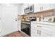 Well-equipped kitchen with stainless steel oven, microwave, quartz countertops and modern white cabinets at 1675 White Oak Way, Decatur, GA 30032